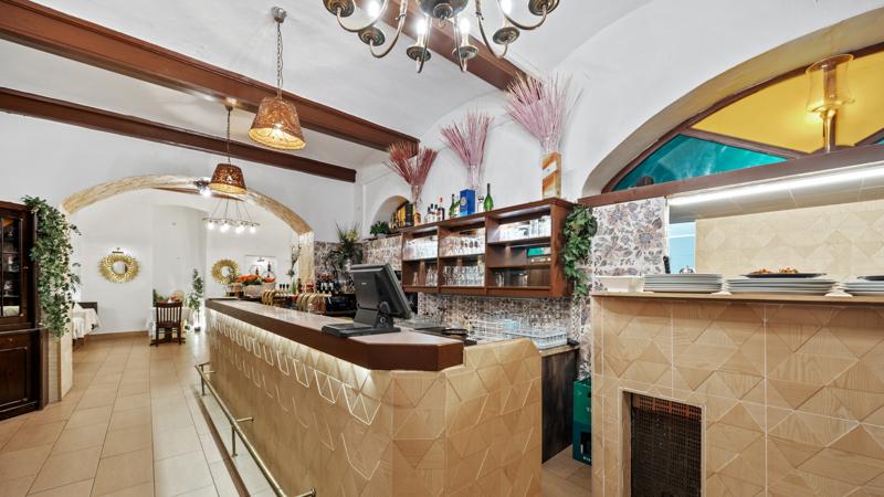 Bar und Tresen im Gewölbe des Volare mit hängenden Lampen und Weinregal